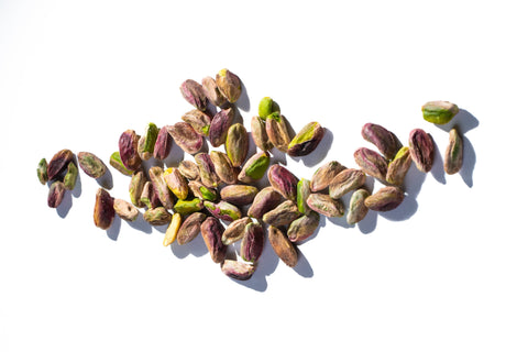 Pistachios scattered on a white background